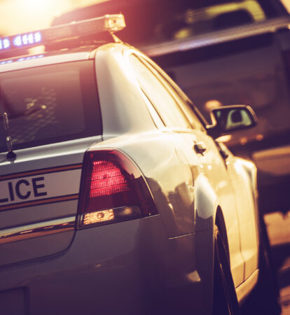 State Police Traffic Stop on a Highway. Police Cruiser with Flashing Lights.